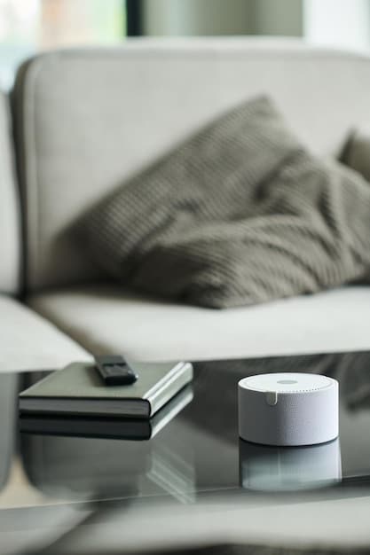 A close-up shot of a smart thermostat on a wall, displaying energy saving settings. The background shows a modern living room.