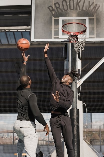 Action shot of a basketball game, with two players vying for the ball. The focus is on their expressions, showing determination and intensity, reflecting the competitive nature of college basketball transfers.