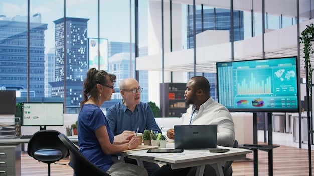 A diverse group of business professionals in a modern office looking at charts and discussing data security, symbolizing proactive compliance efforts.